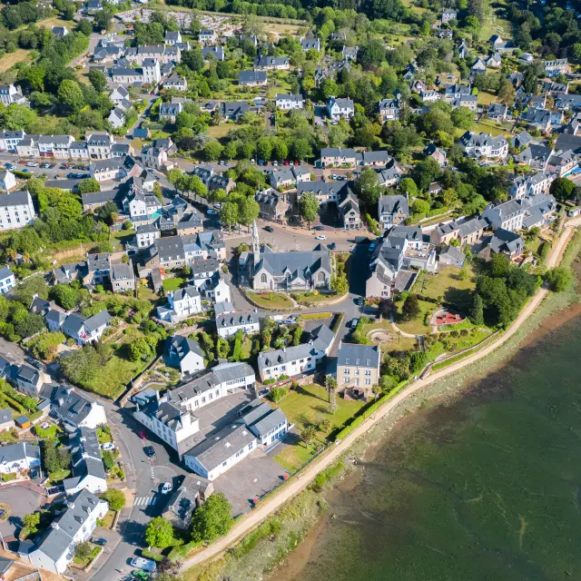 Vue aérienne de l'église Notre Dame Izel Vor et du bourg de La Forêt comprenant des maisons et une partie de l'anse de La Forêt