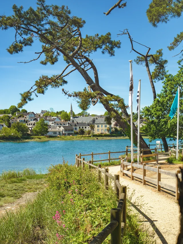 Vue de l'anse de La Forêt à marée haute avec le sentier côtier et le bourg de La Forêt-Fouesnant