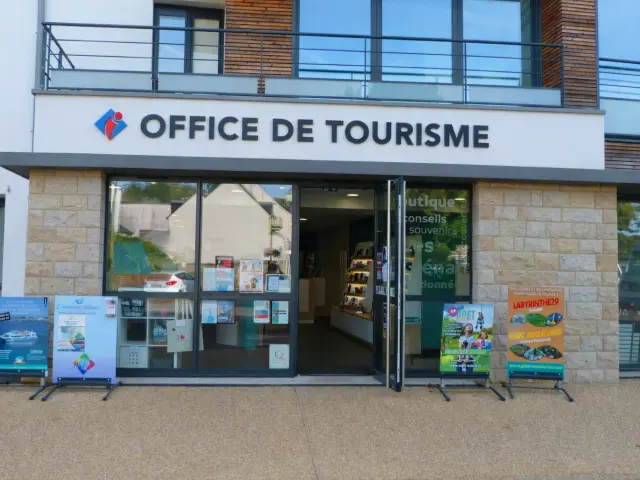 Vue de la façade de l'office de tourisme avec les baies vitrées, la porte est ouverte