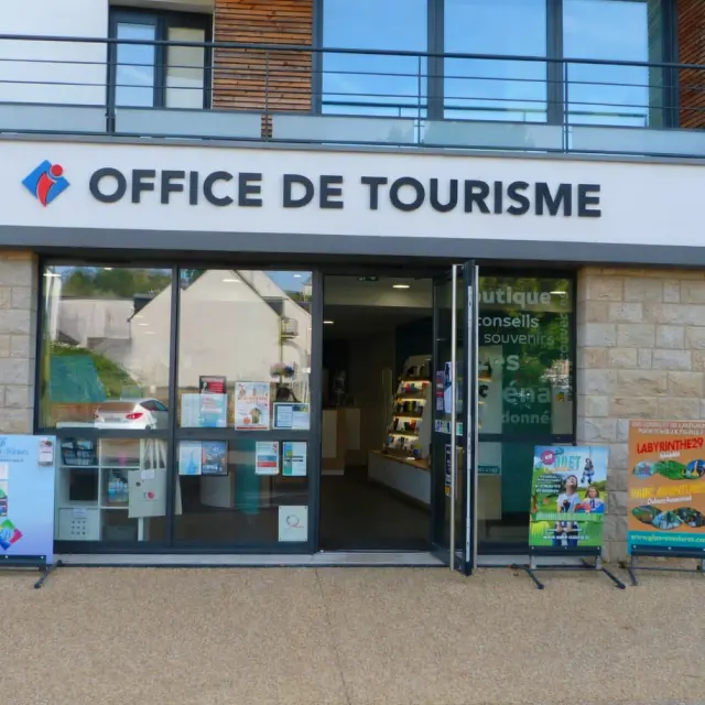 Vue de la façade de l'office de tourisme avec les baies vitrées, la porte est ouverte