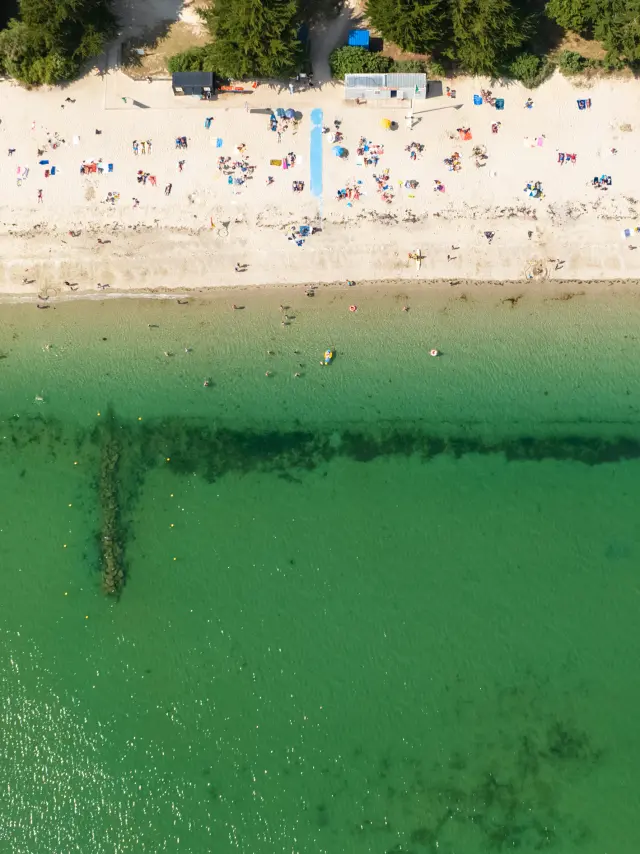 Vue aérienne en été de la plage de Kerleven avec des personnes sur la plage et l'eau turquoise